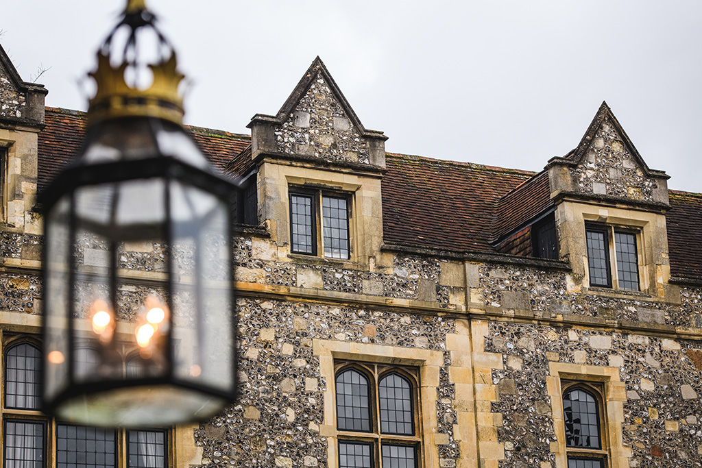 A view of the great hall from the outside, featuring old windows and flint style exterior