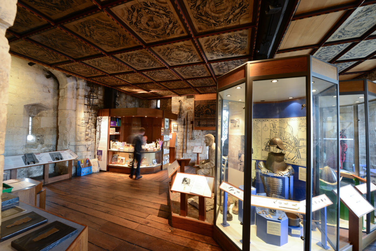 An internal view of Westgate Museum featuring display cabinets of historical artifacts