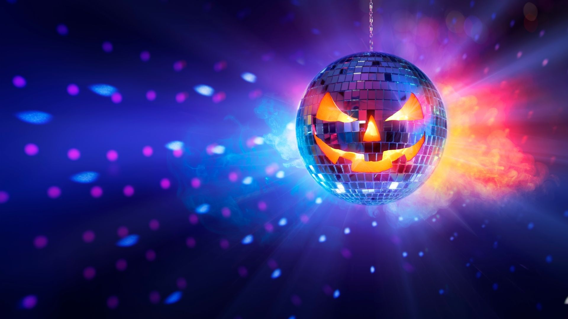 A blue background with a mirror ball and the face of a carved pumpkin