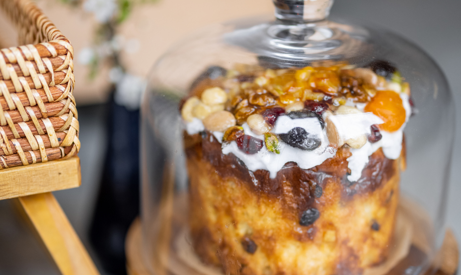 A mixed fruit cake under a glass cloche