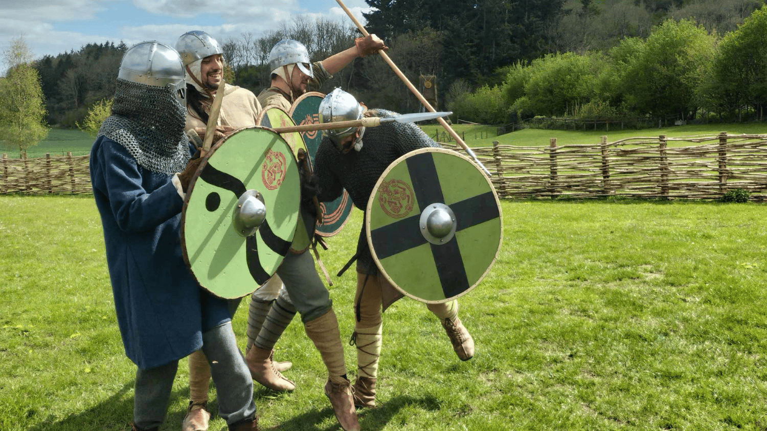 Four Vikings ready for battle holding a shield wall